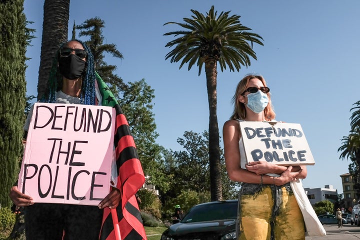 Protesters hold placards during a demonstration in April outside of Los Angeles Mayor Eric Garcetti's home to protest his pro