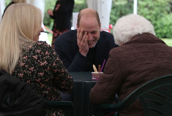 Prince William chats with Betty Magee and her granddaughter, Kimberley Anderson, during a visit to the Queens Bay Lodge Care 