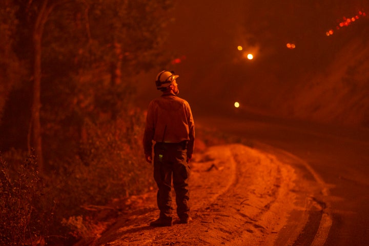 A firefighter keeps watch as flames advance along the Western Divide Highway during the SQF Complex Fire on September 14, 2020, near Camp Nelson, California. Worsening wildfires across the U.S. West are among the more visible signs of global warming.