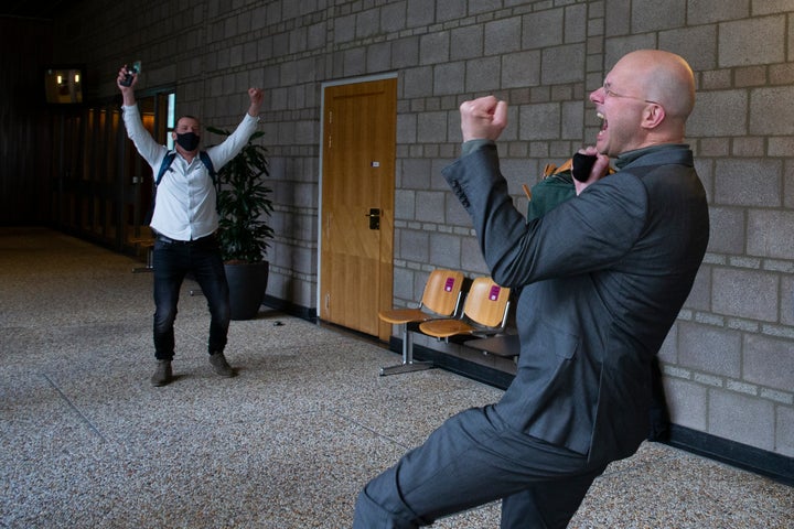 Milieudefensie director Donald Pols, right, celebrates the outcome of the verdict in the court case of Milieudefensie, the Dutch arm of the Friends of the Earth environmental organization, against Shell in The Hague, Netherlands, Wednesday, May 26, 2021. In a landmark legal battle of climate change activists in the Netherlands energy giant Shell was ordered to rein in its carbon emissions. (AP Photo/Peter Dejong)