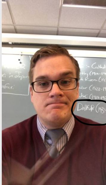 White nationalist teacher Benjamin Welton in a since-deleted photo from the Faculty section of Star Academy's website. On the chalkboard behind him is the name of an Austrian fascist (circled).