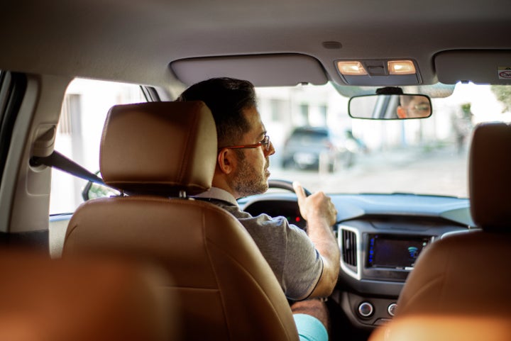 Driver inside the car looking at the rear view mirror