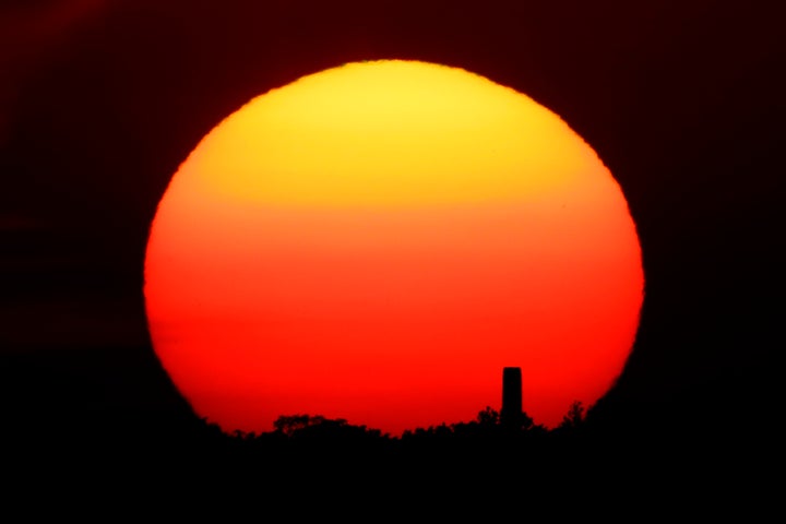 FILE - In this Friday, June 26, 2020 file photo, the sun sets behind a smokestack in the distance in Kansas City, Mo. According to a World Meteorological Organization forecast for the next five years, released on Thursday, May 27, 2021, it'll likely be so hot that there's a 40% chance in the next few years that the globe will push past the temperature limit set by the Paris climate agreement. (AP Photo/Charlie Riedel, File)