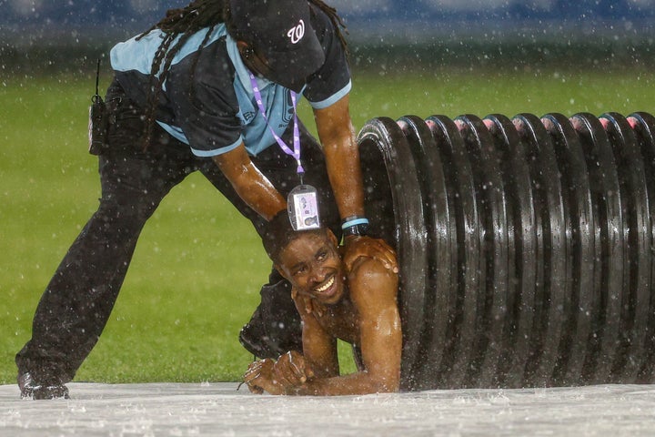A streaker is pulled from the infield tarp roller tube by security during a rain delay between the Cincinnati Reds and against the Washington Nationals at Nationals Park on May 26.