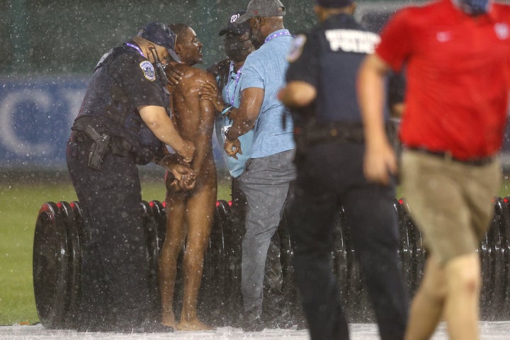 A streaker is arrested by law enforcement and security during a rain delay between the Cincinnati Reds and against the Washington Nationals at Nationals Park on May 26.