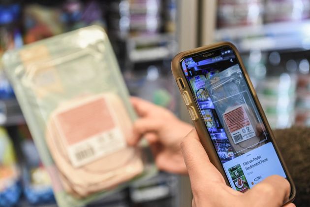 Pourquoi la justice a donné raison aux charcutiers contre l'appli Yuka (Photo d'illustration: une personne utilisant l'application Yuka pour scanner des tranches de jambon. Par ALAIN JOCARD / AFP)