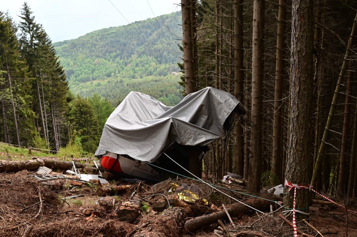 A view shows the cabin's wreckage covered with a tarpaulin on May 26, 2021 on the slopes of the Mottarone peak above Stresa, 