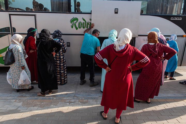 Mujeres temporeras, cargando sus pertenencias en un autobús, regresando a casa desde Lepe, en mayo de 2020.