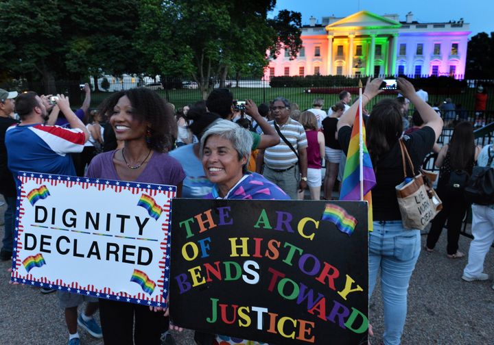 最高裁で平等な結婚の権利を認める判決が言い渡された後、レインボーに染まったホワイトハウスの前で喜ぶ人たち（2015年6月26日）