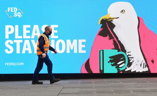 Un passant devant un panneau encourageant la population à rester chez soi à Melbourne le...