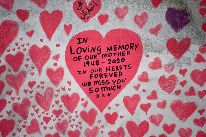 Messages are pictured on hearts painted on the National Covid Memorial Wall, at the embankment on the south side of the River Thames in London