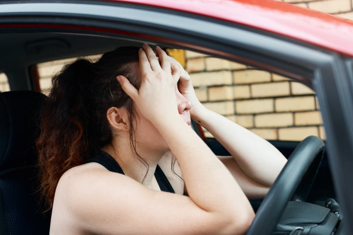 Mujer desesperada al volante del coche.