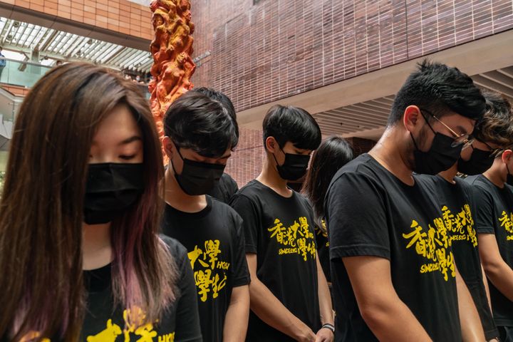 University students take a moment of silence as they gather to clean the Pillar of Shame sculpture by Danish artist Jens Galschiot, to remember the victims of the Tiananmen crackdown in Beijing, at the University of Hong Kong on June 4, 2021.