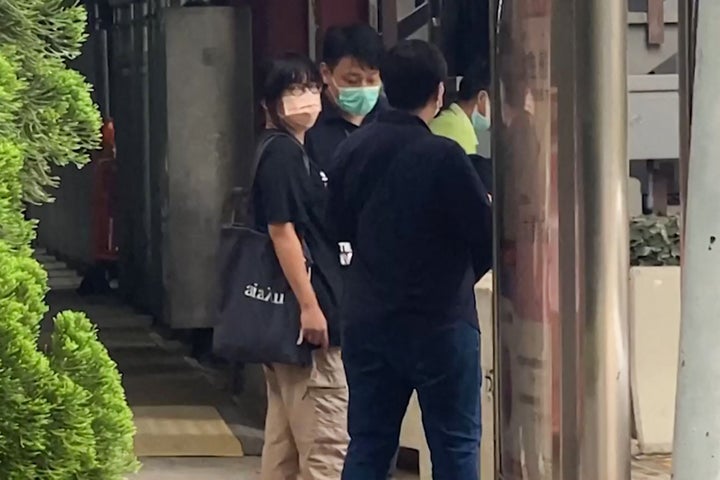 This video frame grab taken from AFPTV footage shows Chow Hang Tung, left, barrister and a leader of the Hong Kong Alliance in Support of Patriotic Democratic Movements of China, being led away by plainclothes police officers after being detained in Hong Kong on June 4, 2021.