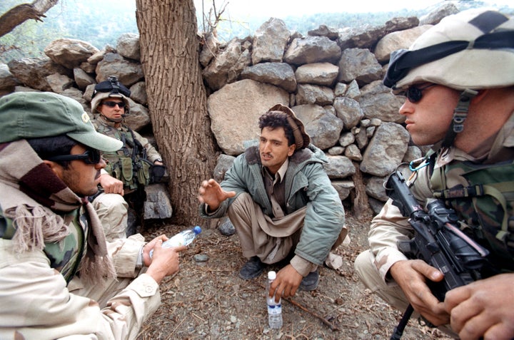 A village suspect is questioned by U.S. soldiers from the 501st Parachute Infantry Regiment with the assistance of an interpreter.