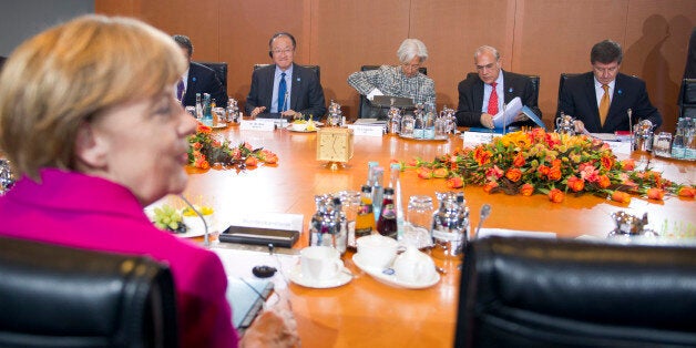 German Chancellor Angela Merkel (front L) sits together with World Trade Organization (WTO) Director-General Roberto Azevedo, President of The World Bank Jim Yong Kim, Managing Director of the International Monetary Fund (IMF) Christine Lagarde, Angel Gurria, Secretary-General of the Organisation for Economic Cooperation and Development (OECD) and Guy Ryder, Director-General of the International Labour Organization (ILO) (background L-R) during a meeting with leaders of economic and financial institutions, at the Chancellery in Berlin March 11, 2015. REUTERS/Stefanie Loos (GERMANY - Tags: POLITICS BUSINESS)