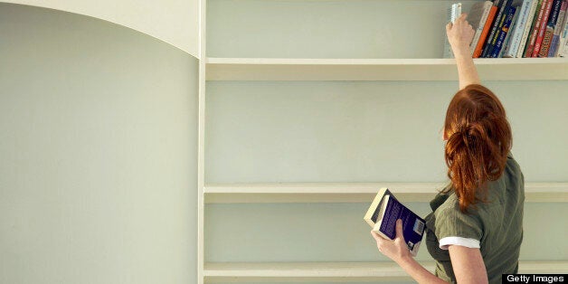 Woman removing books from the shelf