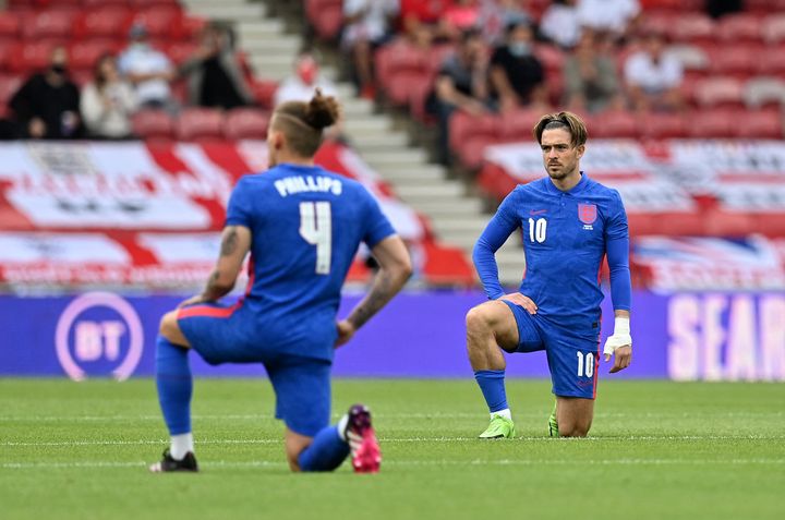 England midfielders Kalvin Phillips (L) and Jack Grealish (R) take the knee ahead of the international friendly football match between England and Romania at the Riverside Stadium in Middlesbrough on Sunday