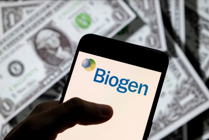 Το λογότυπο της Biogen πάνω στην οθόνη ενός κινητού τηλεφώνου και με φόντο το αμερικανικό δολάριο. (Photo Illustration by Budrul Chukrut/SOPA Images/LightRocket via Getty Images)