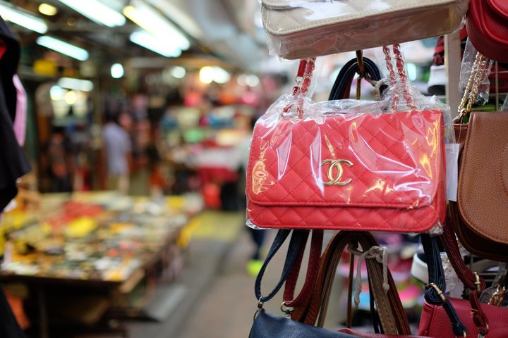 Kuala Lumpur, Malaysia - August 19, 2015: Some fake bags on sale in China Town market in Kuala Lumpur. In this area it is full of small shops selling a plenty of counterfeit merchandise illegally. This area is popular among tourist, and sometimes they are not aware that buying these fake goods is illegal and may lead to problems at the customs.