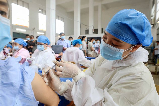 This photo taken on June 3, 2021 shows a health worker administering the Sinovac Covid-19 coronavirus vaccine to a resident in Rongan, in China's southern Guangxi region. (Photo by STR / AFP) / China OUT