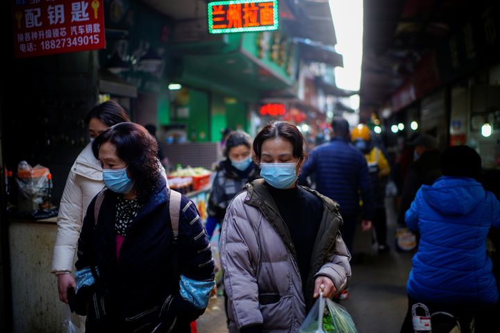 Άνθρωποι με μάσκες στην αγορά της Κίνας