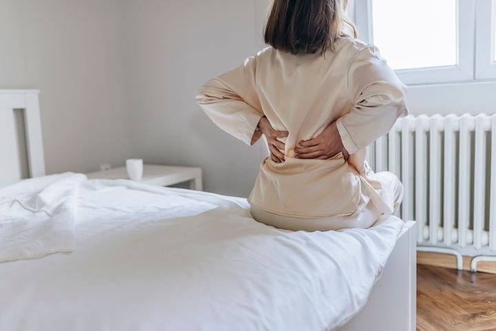 Experts share the stretches you should try when you first wake up in order to improve back pain and alleviate stiffness.