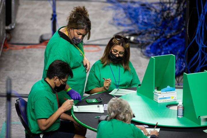 Contractors working for Cyber Ninjas, which was hired by the Arizona state Senate, examine and recount ballots from the 2020 general election in May in Phoenix.