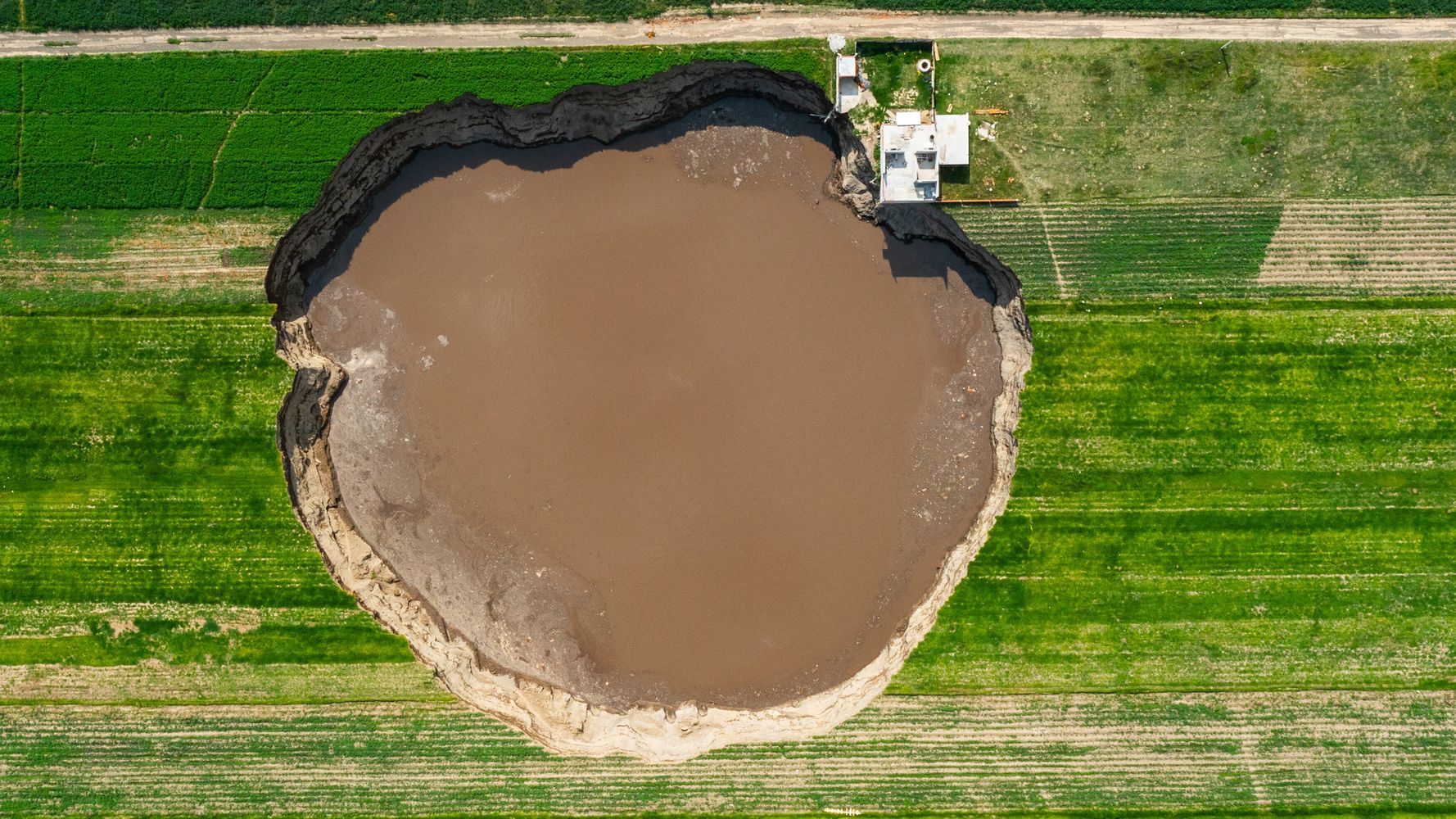 Sinkhole Grows To Size Of Football Field, Threatens House And Traps 2 Dogs