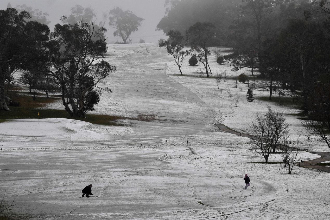 Μια οικογένεια απολαμβάνει τα πρώτα χιόνια της σεζόν σε ένα γήπεδο γκολφ, στο Μπλου Μάουντενς της Αυστραλίας.
