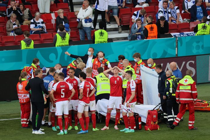 Denmark's players gather around teammate Christian Eriksen, who collapsed on the pitch during a match between Denmark and Finland at the Parken Stadium in Copenhagen on Saturday.