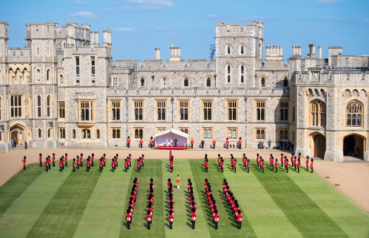 Assembled soldiers from the Queen’s Company First Battalion Grenadier Guards gave a royal salute. Biden arrived Sunday