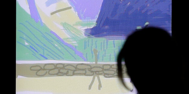 In this photo taken Thursday, Oct. 24, 2013, a woman watches how a painting of Yosemite National Park, made by David Hockney using an iPad, takes shape at an exhibit in San Francisco. A sweeping new exhibit of Hockneyâs work, including about 150 iPad images, has opened in the deYoung Museum in Golden Gate Park, just a short trip for Silicon Valley techies who created both the hardware and software for this magnificent reinvention of fingerpainting. (AP Photo/Eric Risberg)