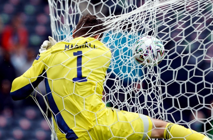 Scotland's goalkeeper, David Marshall, crashes into the back of the net after Patrik Schick's shocking goal.