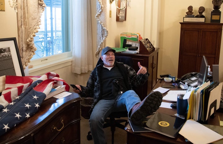 Richard Barnett shows off after breaching the Capitol and Nancy Pelosi's office.