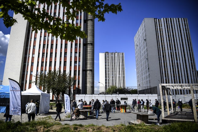 Des personnes font la queue pour recevoir une dose du vaccin Pfizer-BioNTech contre le Covid-19 dans des tentes installées au pied d'immeubles résidentiels dans un lotissement à Noisy-le-Sec, en Seine-Saint-Denis au nord-est de Paris, le 7 mai 2021. (Photo by Christophe ARCHAMBAULT / AFP)
