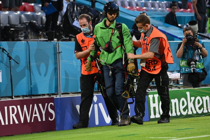 The Greenpeace activist is taken off the pitch. 
