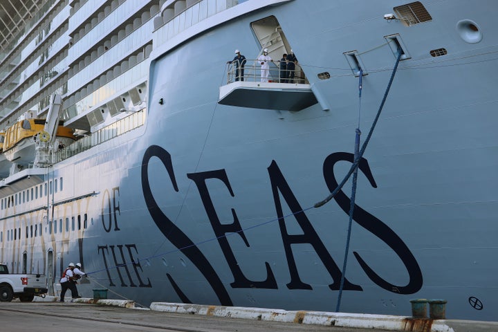 Dockworkers and crew members use ropes to tie the Royal Caribbean&rsquo;s Odyssey of The Seas to its berthing spot at Port Ev