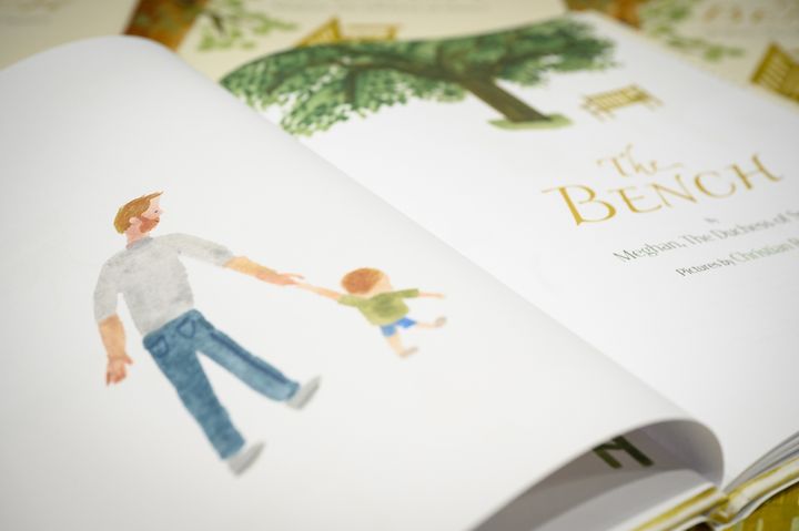 A illustration of a father and son inside a copy of Meghan Markle's book "The Bench."
