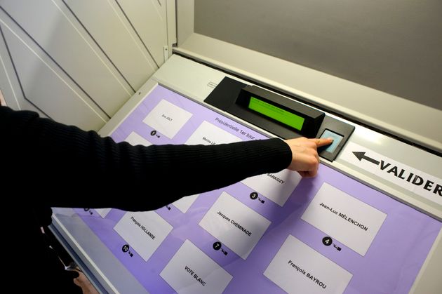 Un électeur clique sur un bouton pour voter avec une urne électronique, le 22 avril 2012, à Mulhouse, dans l'est de la France, dans le cadre du vote du 1er tour de l'élection présidentielle. (Photo SEBASTIEN BOZON/AFP via Getty Images)