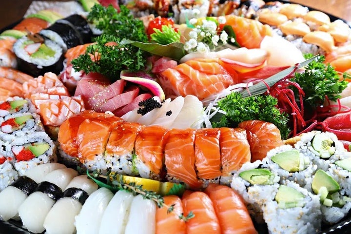 Bandeja con sashimi, sushi y rollos maki.