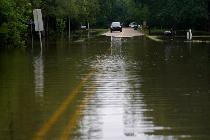 A car stops in front of neighborhood flooding after Tropical Storm Claudette passed through, in Slidell, La., on Saturday.