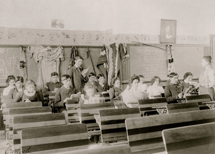 Students are seen reading in a classroom at the Indian Industrial School, in Carlisle, Pennsylvania, in 1901. The boarding sc