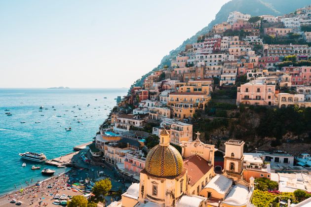 Positano's colourful cityscape with leisure and fishing boats on the sea