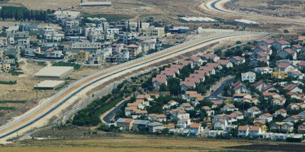 FILE - This Tuesday, July 29, 2003 file photo is an aerial view over West Bank showing a Palestinian village, left, and a Jewish settlement, right, separated by a wall, part of the separation fence Israel is building. Nine months of U.S.-driven diplomacy have left Israelis and Palestinians less hopeful than ever about a comprehensive peace agreement to end their century of conflict. Although a formula may yet be found to somehow prolong the talks past an end-of-April deadline, they are on the brink of collapse and the search is already on for new ideas. (AP Photo/Lefteris Pitarakis)