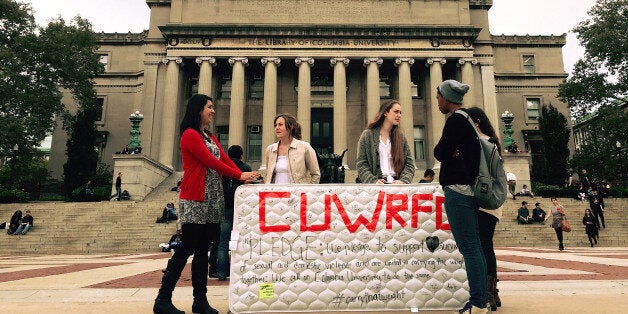 NEW YORK, NY - OCTOBER 29 : Students stand in front of the Library of the Columbia University with a mattress in support of Emma Sulkowicz's project against sexual assault, 'Carry That Weight' in which she carries her mattress around campus until her alleged rapist is expelled from the university in New York, United States on October 29, 2014. (Photo by Selcuk Acar/Anadolu Agency/Getty Images)