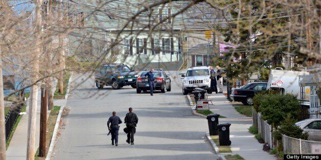 Police monitor a locked down street as a search for the second of two suspects wanted in the Boston Marathon bombings takes place on April 19, 2013 in Watertown, Massachusetts. Dzhokhar and Tamerlan Tsarnaev, suspected of bombing the Boston marathon, appear to hail from Russia's war-torn Chechnya but had been in the United States for several years. Tamerlan reportedly died in a shootout with police on April 19 and his yournger brother fled and is being sought by police. AFP PHOTO/Stan HONDA (Photo credit should read STAN HONDA/AFP/Getty Images)