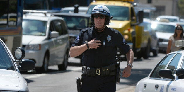 DENVER, CO. - AUGUST 15: A Denver Police officer secures a crime scene on Colfax Avenue after a shooting between Broadway and Lincoln Street near the Colorado Capitol Thursday morning in Denver, CO August 15, 2013. Three people are in custody and a gun has been recovered, no injuries were reported. Witnesses described the incident as a 'shootout' between two people, but police could not confirm that. (Photo By Craig F. Walker / The Denver Post)