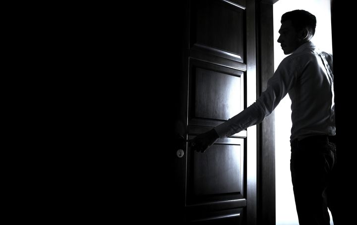 Man opens the door to dark room