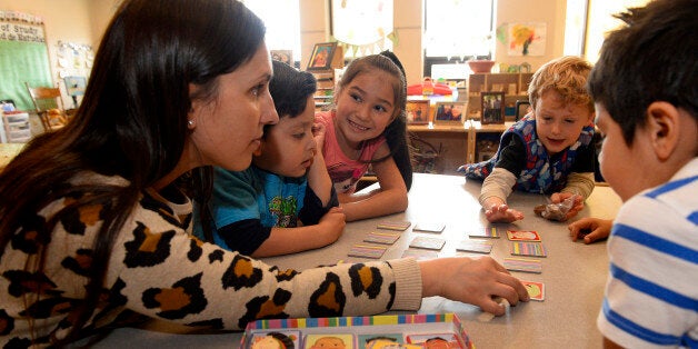 BOULDER, CO - MARCH 30: Preschool teacher Fernanda Perez Chaves, {cq}, left, plays a memory game called 'I Never Forget a Face', with faces from all over the world, with students, from left to right, Elijah Hernandez, 4, Juliette Martinez, 5, in pink, Cohen Rose, right, during class at the Mapleton Early Childhood Center on March 30, 2016 in Boulder, Colorado. Preschools are looking at creative ways to incorporate gender and sexual diversity in their schools. At the Mapleton Center teachers post pictures of children's families on walls, allow kids to bring framed photos of their family into class and read diverse books to them. The family photos not only make children feel more comfortable in class but also help to show their classmates the diversity in each family. (Photo by Helen H. Richardson/The Denver Post via Getty Images)